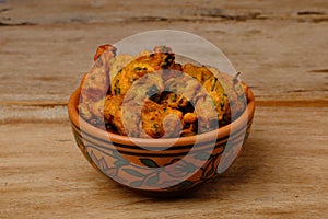 Indian snack pakora in a bowl on wooden background