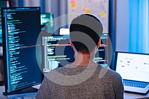Indian software development working on coding computer screen and flowchart at night in modern office