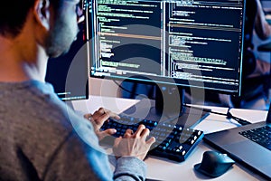 Indian software development working on coding computer screen and flowchart at night in modern office