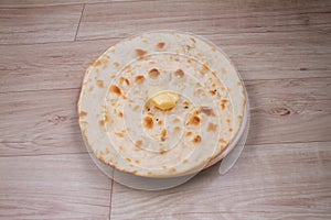 Indian special flat bread also known as butter tandoori roti or naan, served in a white ceramic quarter plate