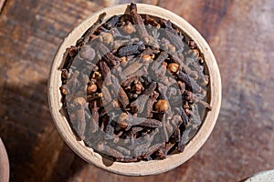 Indian spices collection, dried aromatic cloves flower buds and another spices in clay bowls