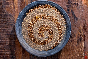 Indian spices collection, dried coriander seeds in clay bowl top view