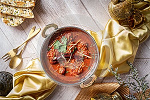 Indian spices Jodhpuri Laal Gosht or beef karahi with roti and kulcha served in a dish isolated on dark background top view of