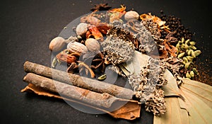 Indian spices on a table with Indian bay leaf, javitri, dry turmeric dust, nutmeg, garam masala