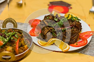 Indian spicy dry mutton curry with fresh salad on table top.