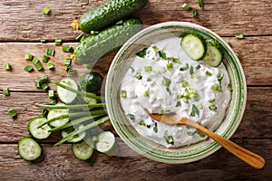 Indian spicy sauce raita with herbs and cucumber close-up in a b