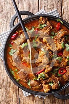 Indian spicy stew Lamb rogan josh closeup in a pan. Vertical top view