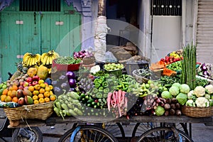 Indian street vendor with fresh vegetables and fruits