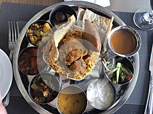 Indian style Thali with curries, chicken, rice, salad, papadam etc.