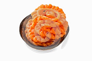 Indian sweet jalebi in coconut shell cup on white background
