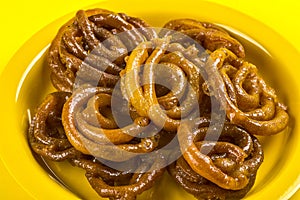 Indian sweet jalebi, indian dessert jalebi or imarti or imarati or jilbi on yellow background