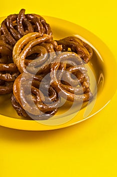 Indian sweet jalebi, indian dessert jalebi or imarti or imarati or jilbi on yellow background