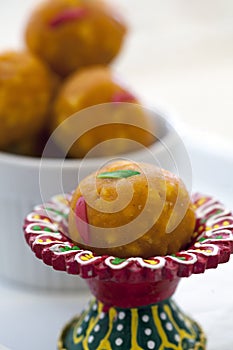 Indian sweet laddu in a colorful red dish