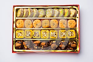 Indian sweets or Mithai for diwali festival with oil lamp or diya and gift box