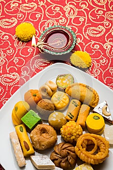 Indian sweets or Mithai for diwali festival with oil lamp or diya and gift box