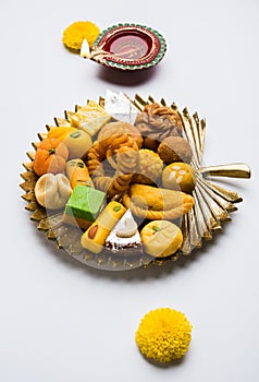 Indian sweets or Mithai for diwali festival with oil lamp or diya and gift box