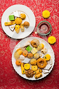 Indian sweets or Mithai for diwali festival with oil lamp or diya and gift box photo