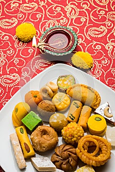 Indian sweets or Mithai for diwali festival with oil lamp or diya and gift box photo