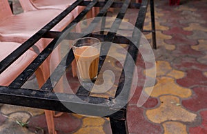 Indian tea in a small tea glass on a metal bench