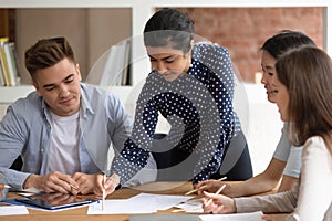 Indian team leader explain material to diverse groupmates