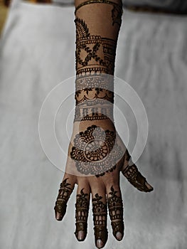 Indian Traditional Bridal Mehendi or Henna design on bride hand. Groom and bride art shown in Henna Design.