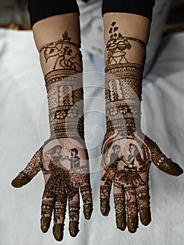 Indian Traditional Bridal Mehendi or Henna design on bride hand. Groom and bride art shown in Henna Design.