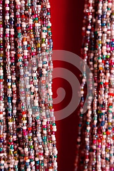 Indian traditional colorful beads glass necklace on red background as asian fashion concept.