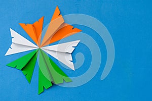 Indian tricolor paper planes arranged in circular shape on blue background. Conceptual image for Indian national day celebration a
