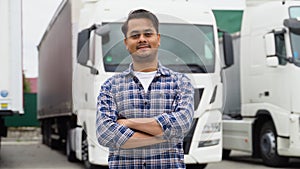 Indian truck driver standing with arms crossed on truck parking lot and looking at camera. Asian trucker driving truck