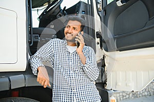 Indian truck driver tending a client on the phone