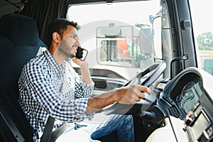 Indian truck driver tending a client on the phone