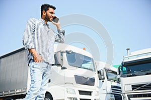 Indian truck driver tending a client on the phone