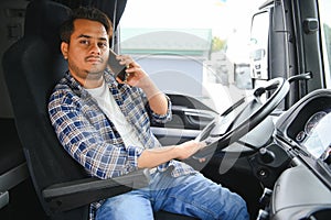 Indian truck driver tending a client on the phone.