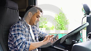 Indian trucker sits in his truck and using truck gps navigation