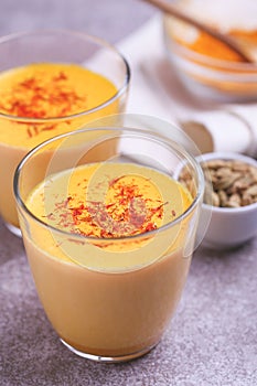 Indian turmeric milk with saffron, cardamom and turmeric. Copyspace