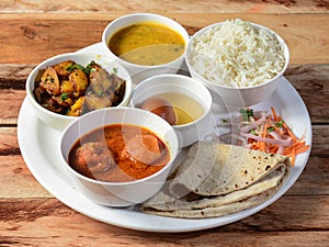 Indian Veg Kofta curry Thali / food platter consists variety of veggies, lentils, sweet dish, snacks etc., selective focus