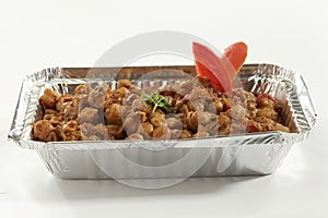 Indian vegetable dish Chana masala in metal foil tray.