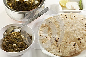 Indian vegetable food Spinach with cottage cheese with raw vegetables with chapati.