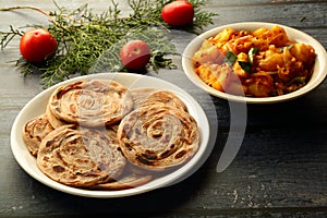 Indian vegetarian cuisine- - wheat paratha with dum aloo.