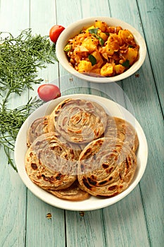 Indian vegetarian cuisine- - wheat paratha with dum aloo.