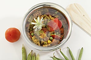 Indian vegetarian dish Mix vegetable in steel pot with raw vegetables.