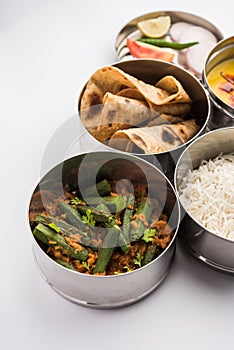 Indian Lunch box or tiffin - Spicy Ladies Finger, dal fry, rice and chapati photo