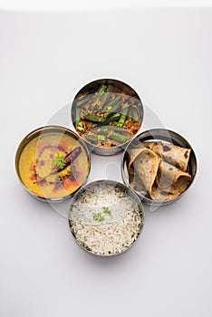 Indian Lunch box or tiffin - Spicy Ladies Finger, dal fry, rice and chapati photo