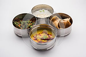 Indian Lunch box or tiffin - Spicy Ladies Finger, dal fry, rice and chapati photo