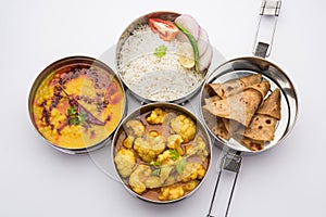 Indian Lunchbox or Tiffin includes Cauliflower Masala, Dal Fry, Rice, Chapati and salad photo