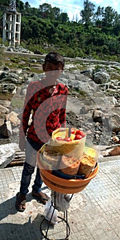 An indian village boy selling masala mix snacks at tourist place district jabalpur