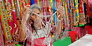 an indian village girl selling women artificial jwellary item into the store