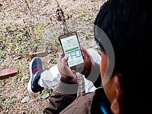 An indian village man using smart phone at agriculture land in india dec 2019