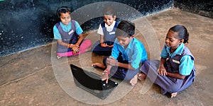 An indian village school students operating laptop in the classroom