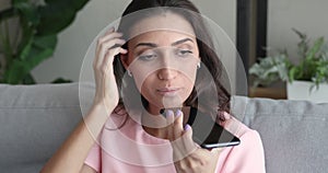 Indian woman chatting with friend by smartphone using speakerphone